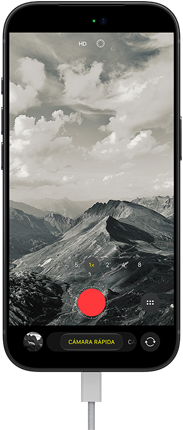 iPhone 18 Pro, parte frontal, se muestra un paisaje montañoso, con la interfaz de la app Cámara superpuesta en modo de cámara rápida, con el cable de corriente conectado al puerto de carga