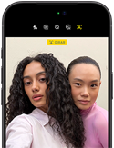 iPhone 18 Pro, negro, parte frontal, dos modelos posan para la cámara, para demostrar la cámara frontal Center Stage